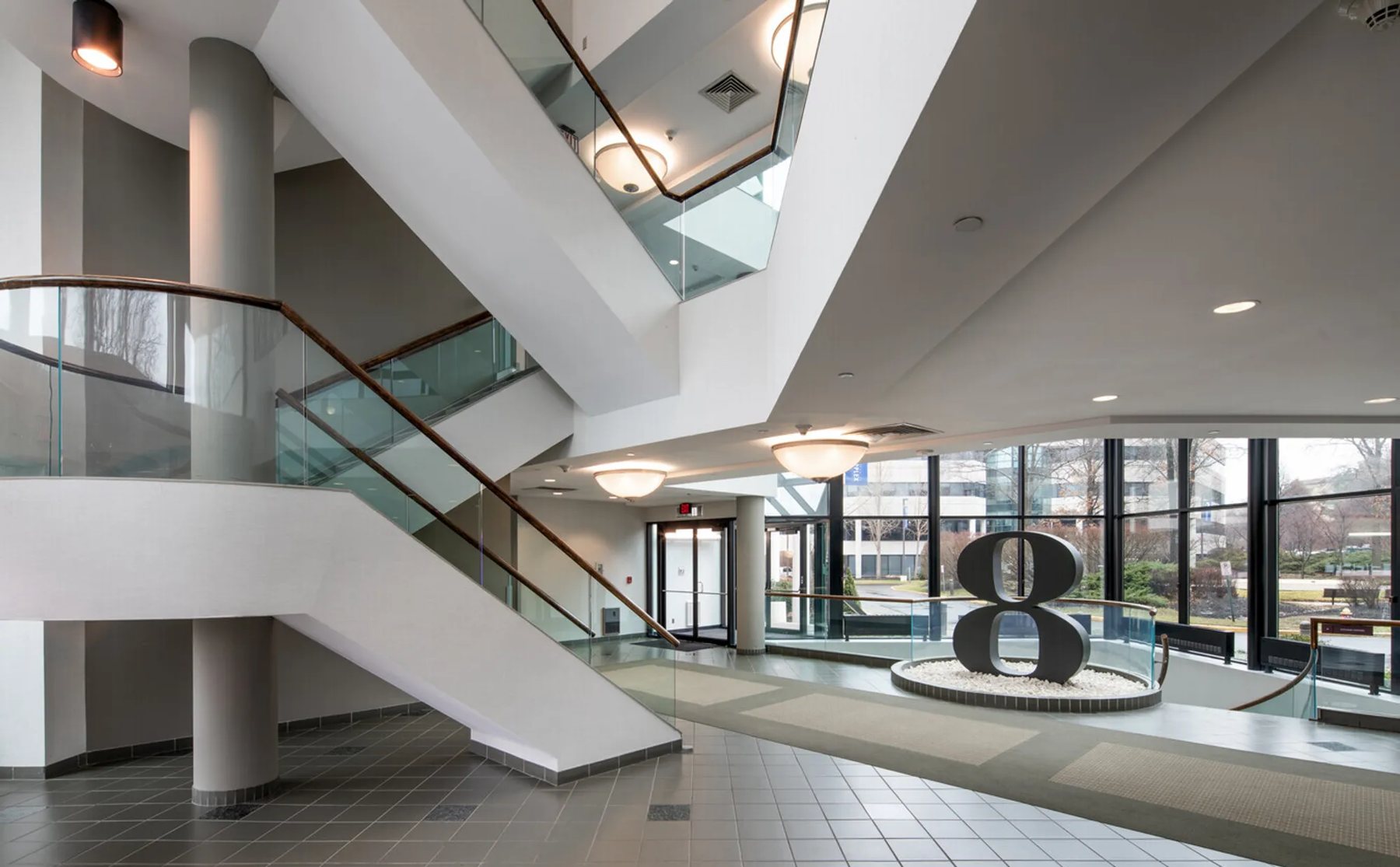 The two-story lobby of Building Eight with its glass stair and sculptural 8