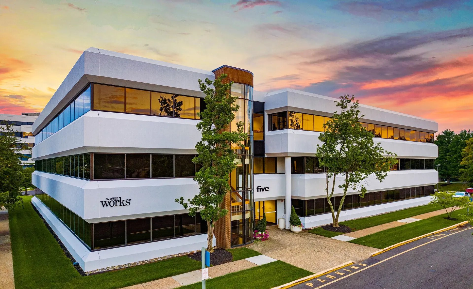 Building Five at dusk with The Office Works signage on the facade
